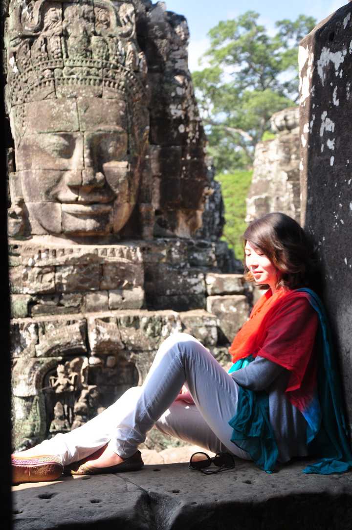 拍摄于柬埔寨-吴哥窟,背景同样是大面积的灰色,运用鲜艳的围巾,人物也