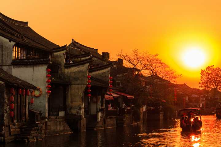 喜欢古镇的黄昏,站在桥头,看着木船"吱呀吱呀"地迎着夕阳远去,有身在