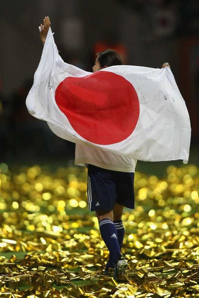 (夺冠后庆祝的日本女足,注意看她背后的日本国旗上面,画着大空翼.)