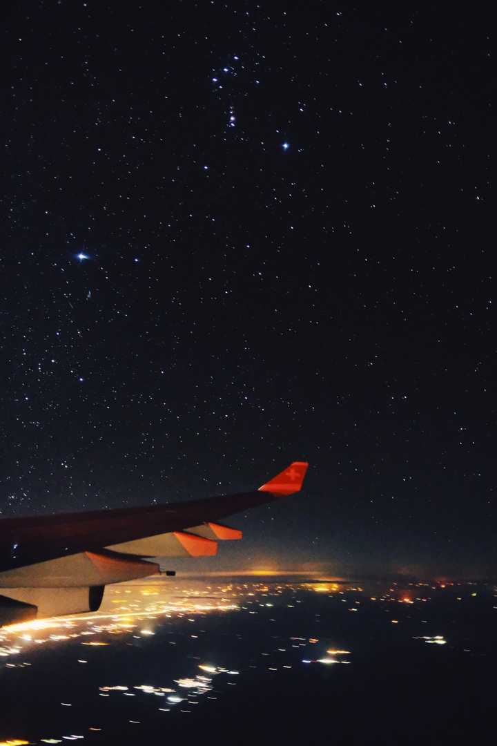 瑞士航空的飞机上,从窗户中拍摄到的满天星空和城市灯光