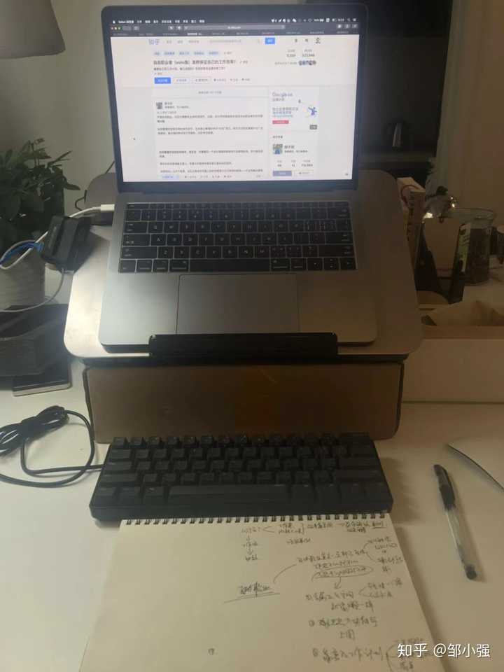 工作台包括电脑支架,机械键盘,白纸,笔,无线鼠标