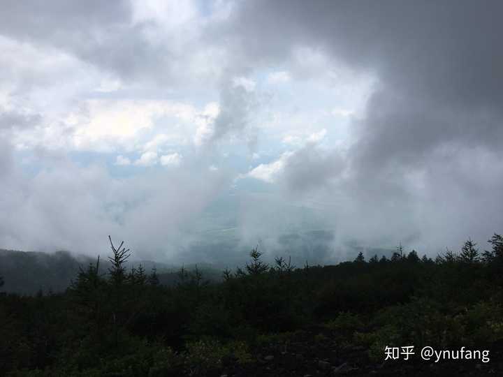 阳光拨开云雾,山脚的景色变得清晰生动.