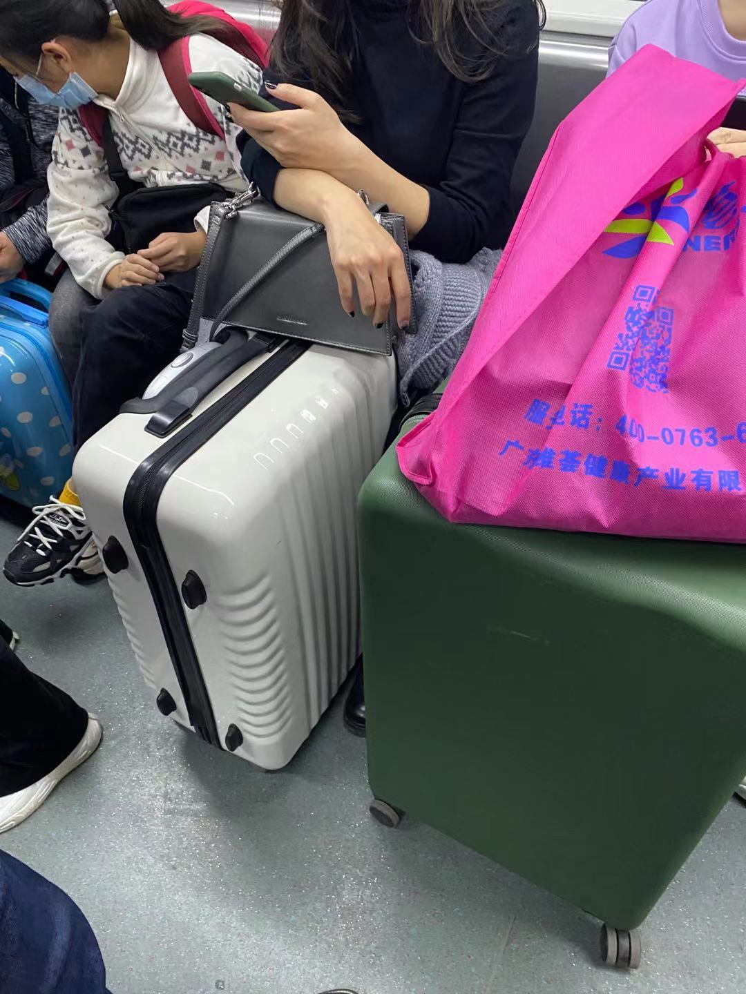 广州阿姨带东西的工具,小拖车,塑料袋里装满东西地铁上,满眼都是行李
