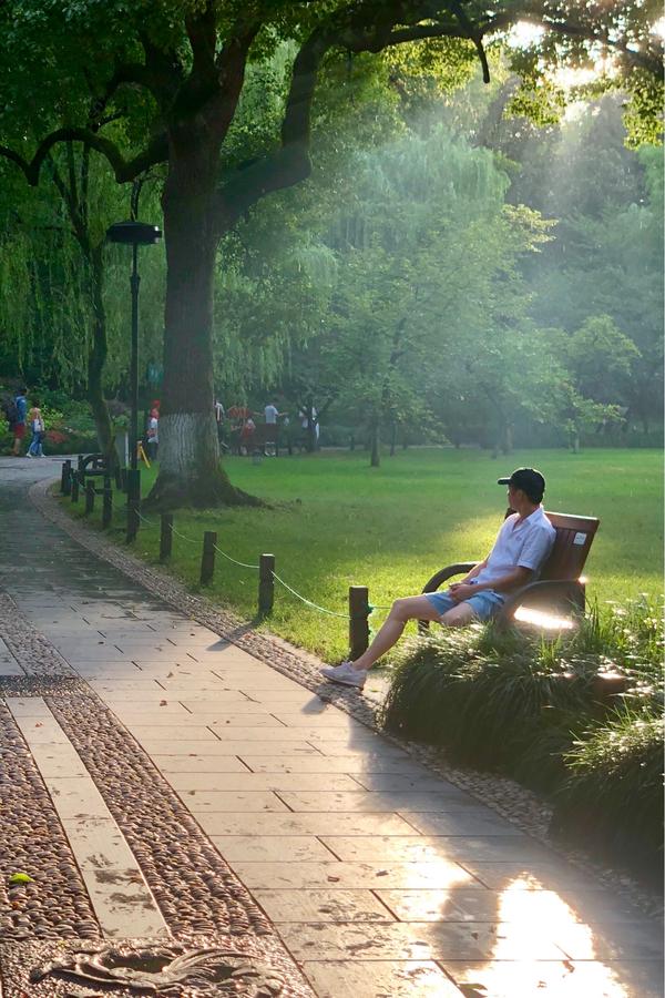 杭州西湖公园,傍晚刚下完雨,看到这个场景很喜欢,就随便找了个路人给