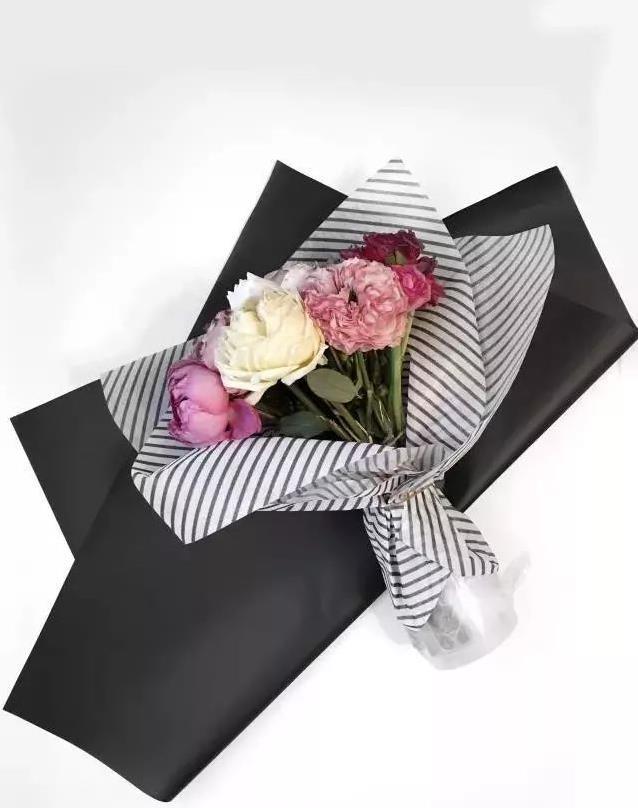 再用一张黑色黑色晨雾纸也做斜角对折,同样包裹花束