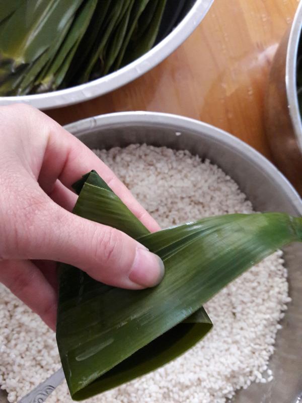 这种小三角粽适合叶片较长的芦叶来包裹 , 包粽子的糯米最好在包之前