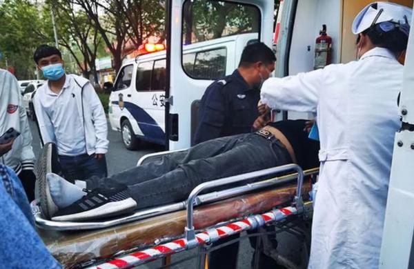 医生及警民合力将患者送上救护车.(阿克苏市公安局张梓薇 摄)