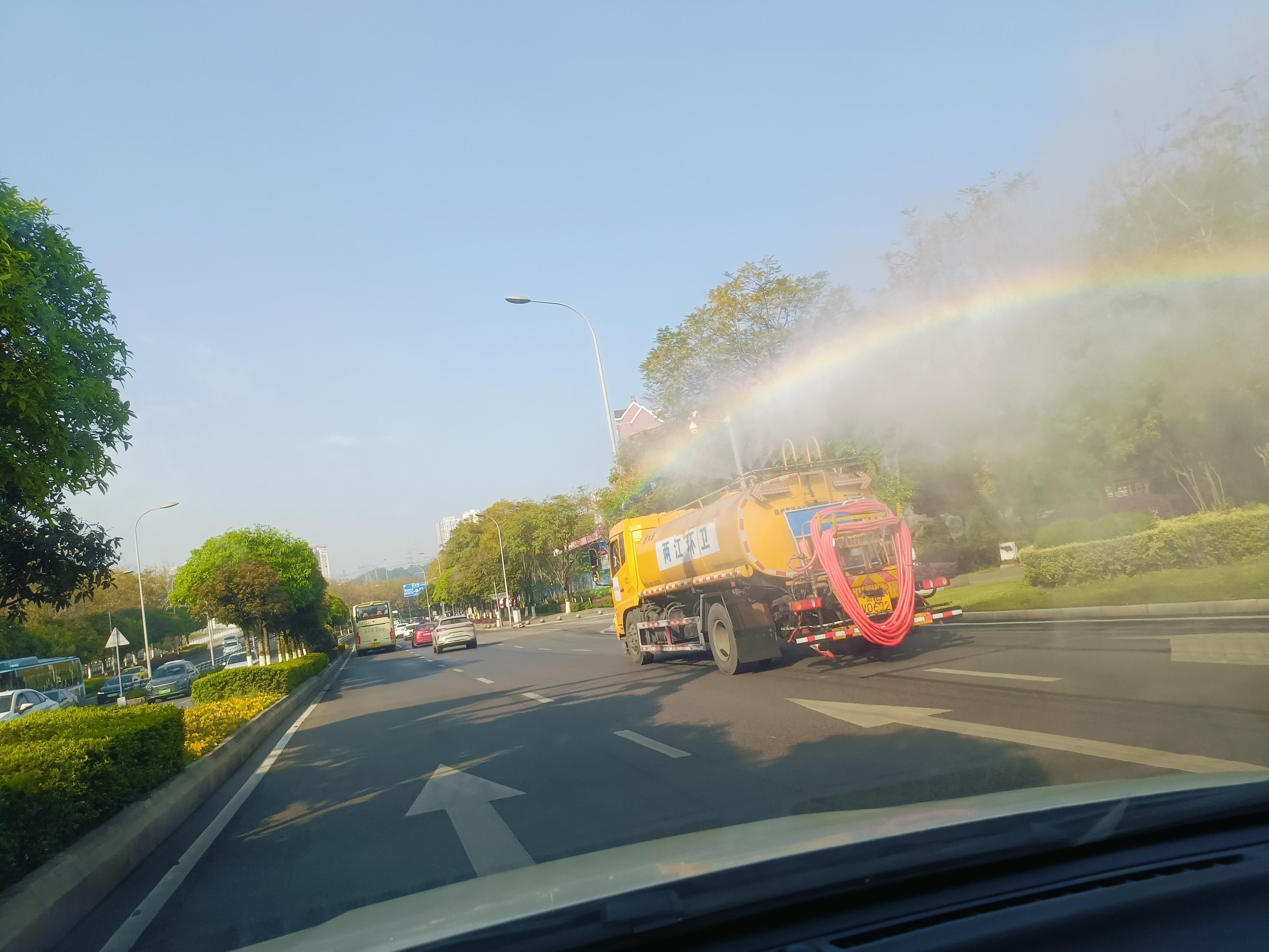 一辆洒水车在前面,阳光映在水珠上,映射出彩虹. #我的摄影日记 发布