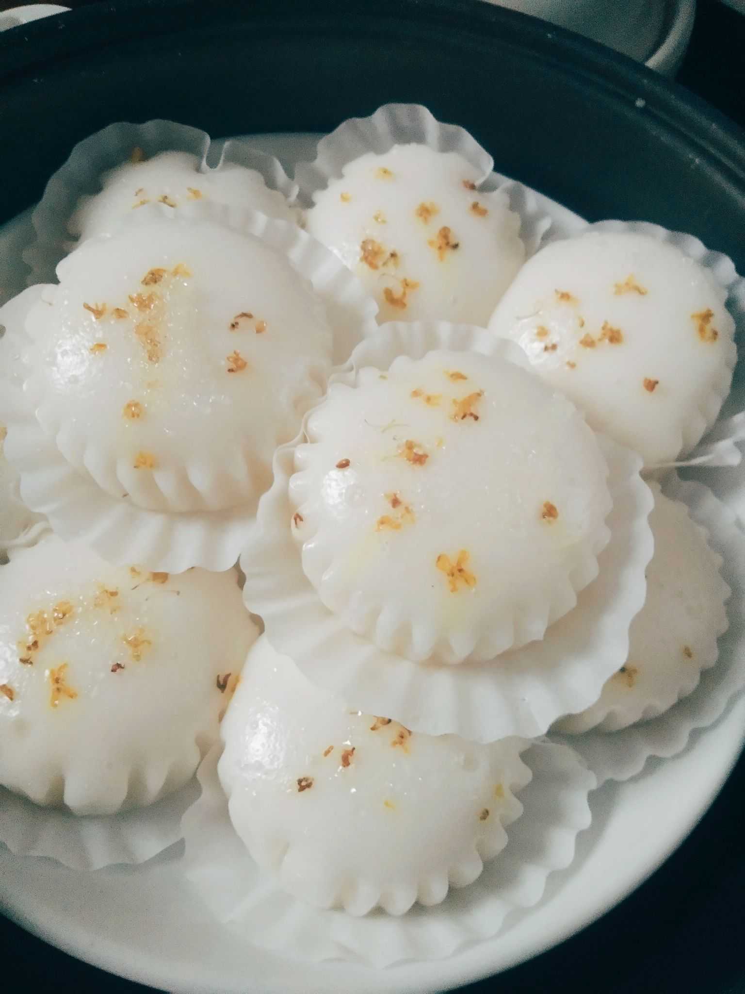 第一次吃是室友请吃饭一个小蒸笼里很多一小块一小块的桂花糕上面撒