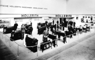 1934 年，德霍梅格在柏林国际办公用品展上展示大量霍尔瑞斯机器。