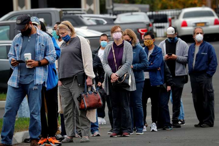 图为在美国纽约郊区一处投票站,选民戴口罩排队等候投票.
