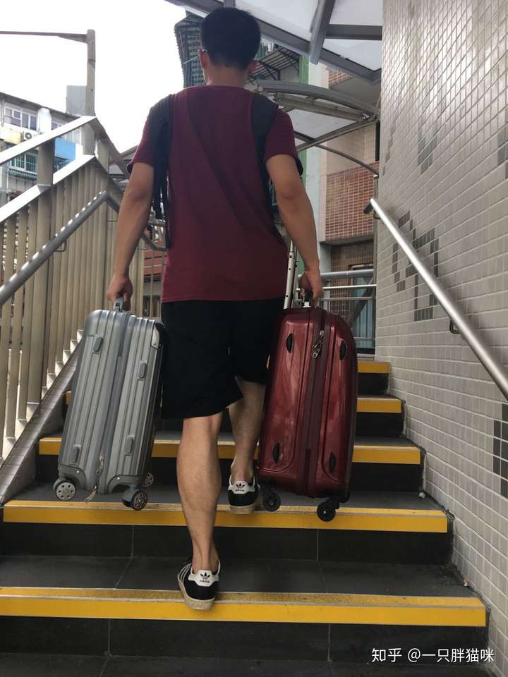 情侣旅游男的帮女的背包拉行李箱在男的看来很好笑吗