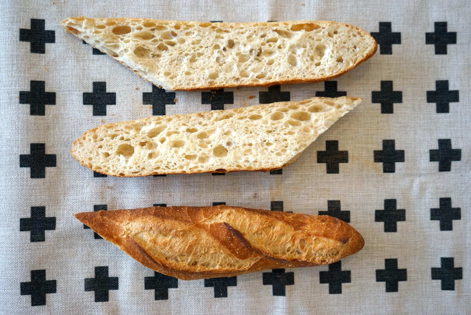 一个成年的欧洲男性面包师手里拿着一个圆形的新鲜面包。一个男人在面包房拿着一个放在酸面包和法棍上的无酵面包照片摄影图片_ID:411430605-Veer图库
