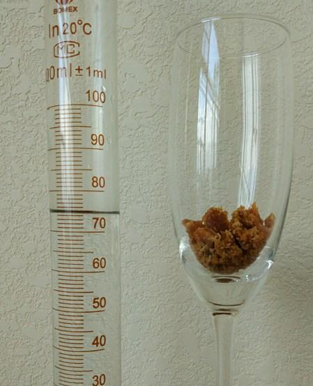 称10克切下来的糖沙倒进喝香槟的玻璃杯,用量杯量75毫升烧开的山泉水