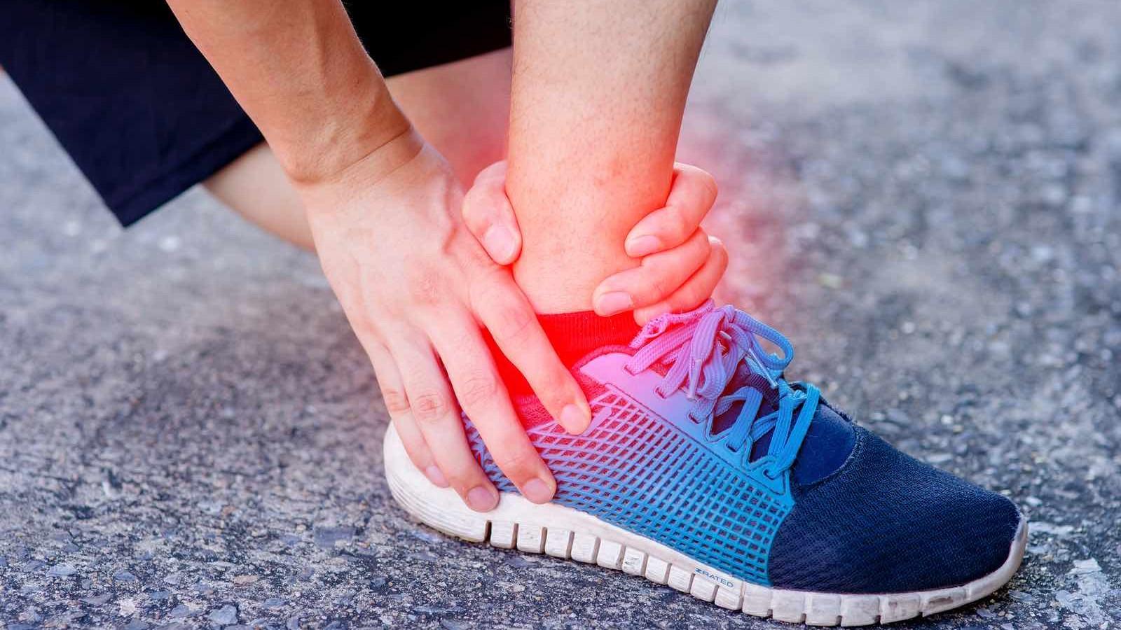 运动跑步扭伤脚踝。女运动员触碰疼痛扭曲照片摄影图片_ID:170757048-Veer图库