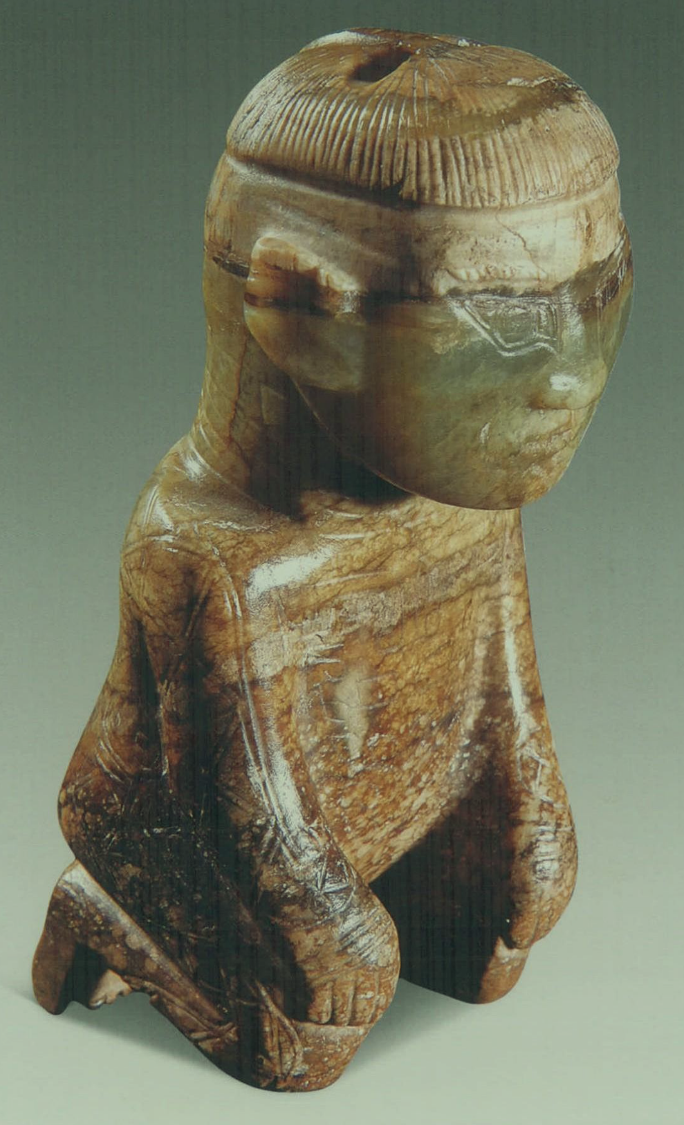 妇好墓出土的商代圆雕跽坐玉人背后的「发条」状物是做什么用的?