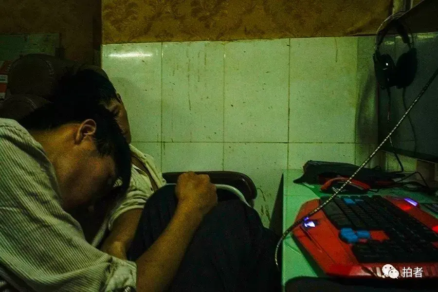 三和人力市场附近的小巷中,网吧老板的孩子在门口玩手机,网吧内