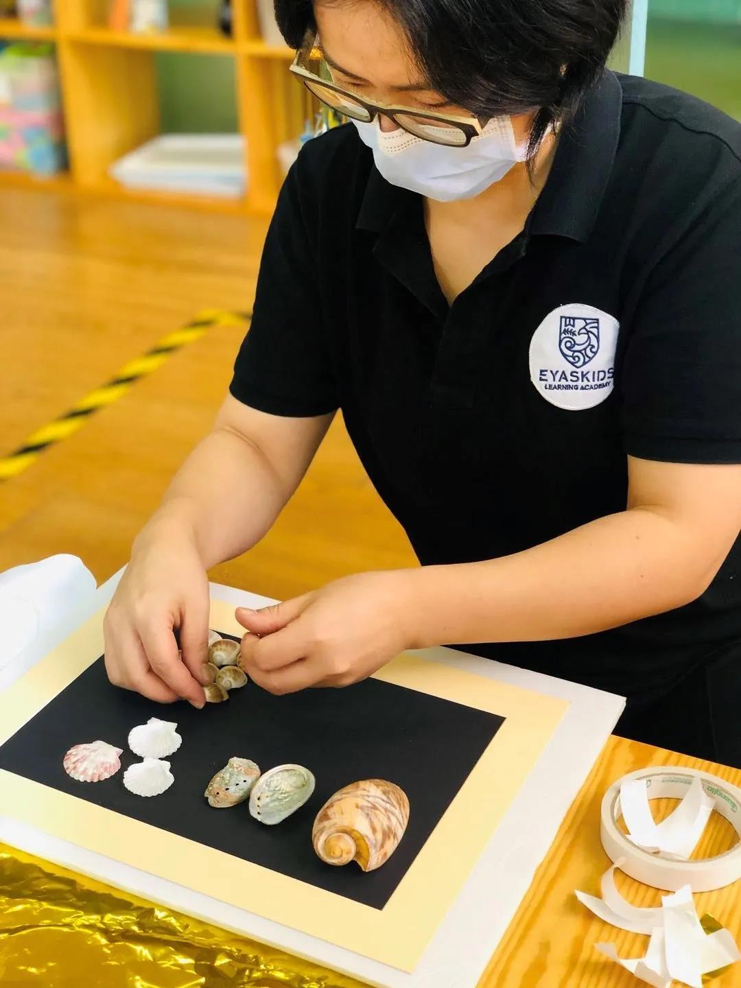 见到micky时,她正仔细地将贝壳一颗颗粘到海报板上.