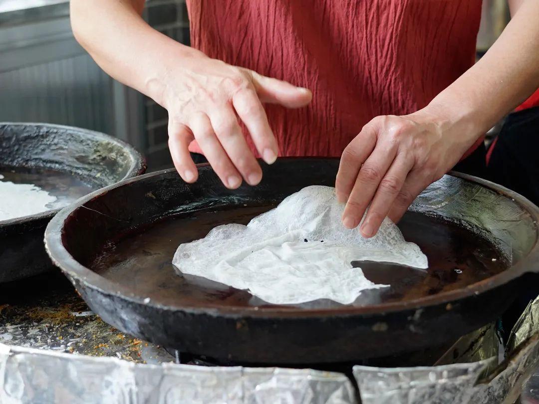 首先将大米打成米浆放在大盆里面用力拍打,使其米浆搅拌均匀,然后将