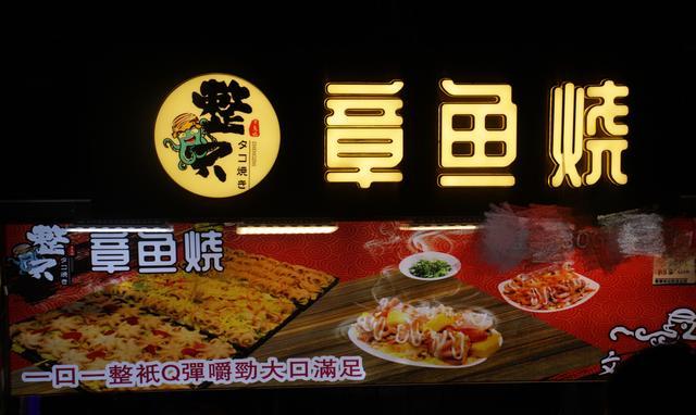 这个摊位经营的是章鱼烧,招牌就叫整只章鱼烧,意思是每粒章鱼烧里都有