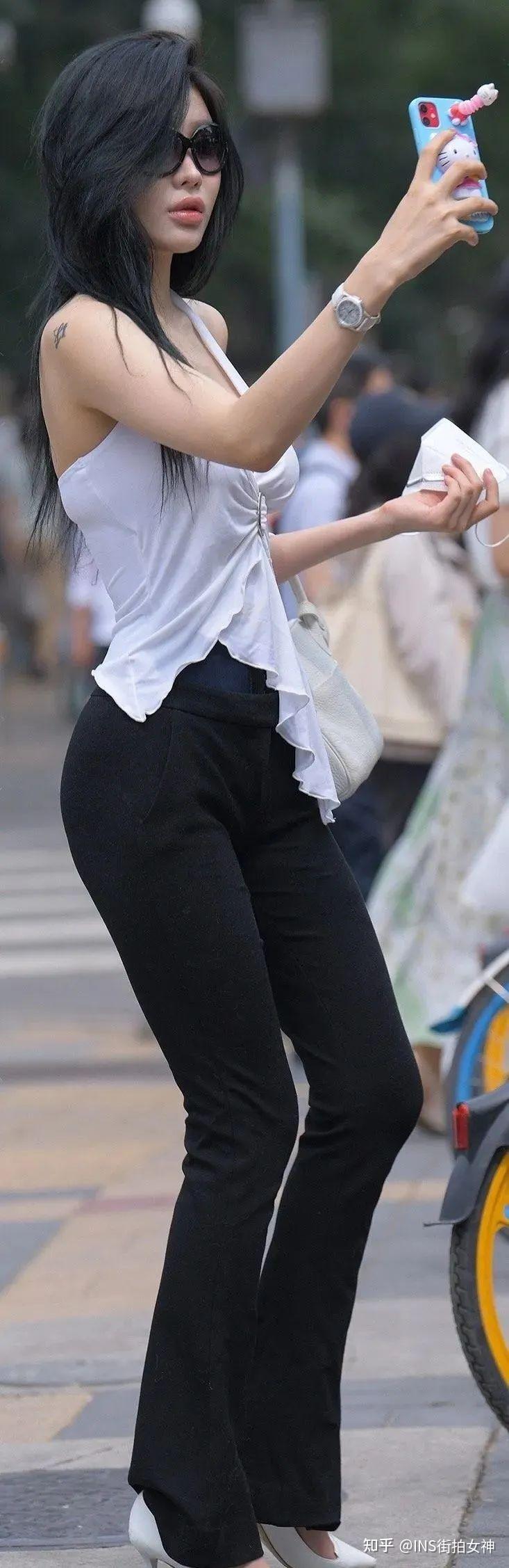 街拍女神:黑色紧身裤白色露背上衣的时尚女生