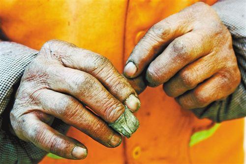 这是一双环卫工人的手,布满老茧,因为长年清理垃圾,污垢已经深入指甲