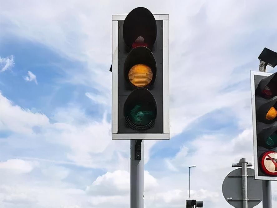 直接通过路口;如果还没通过停止线,就要停车,否则会视为"闯黄灯"!