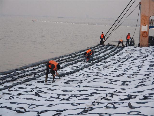 软体排铺设至预定位置后,人工将砂肋条穿过砂肋套,把泥浆泵吹砂口和砂