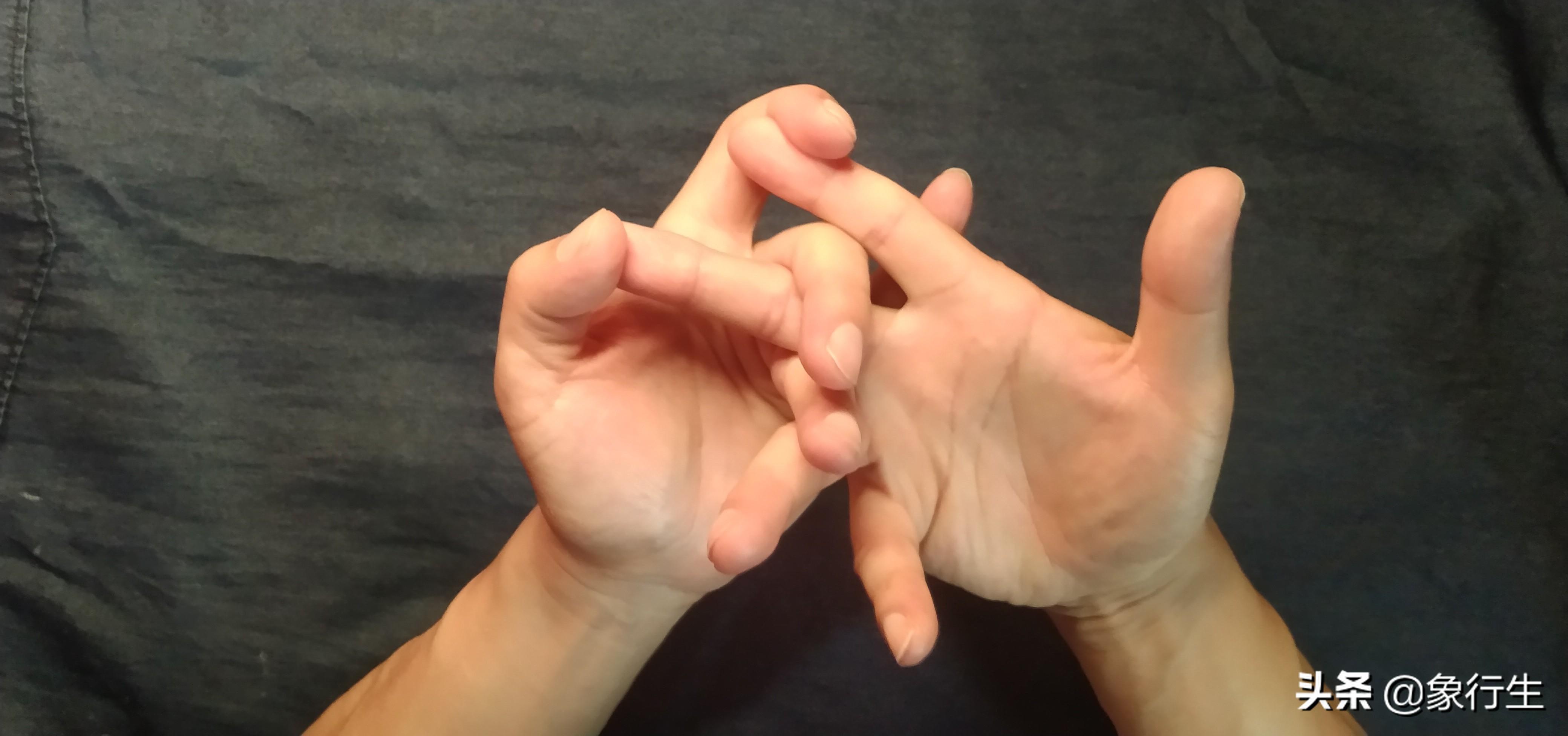 右手小拇指和右手大拇指相扣,形成环状,左右手无名指相钩直立.6.