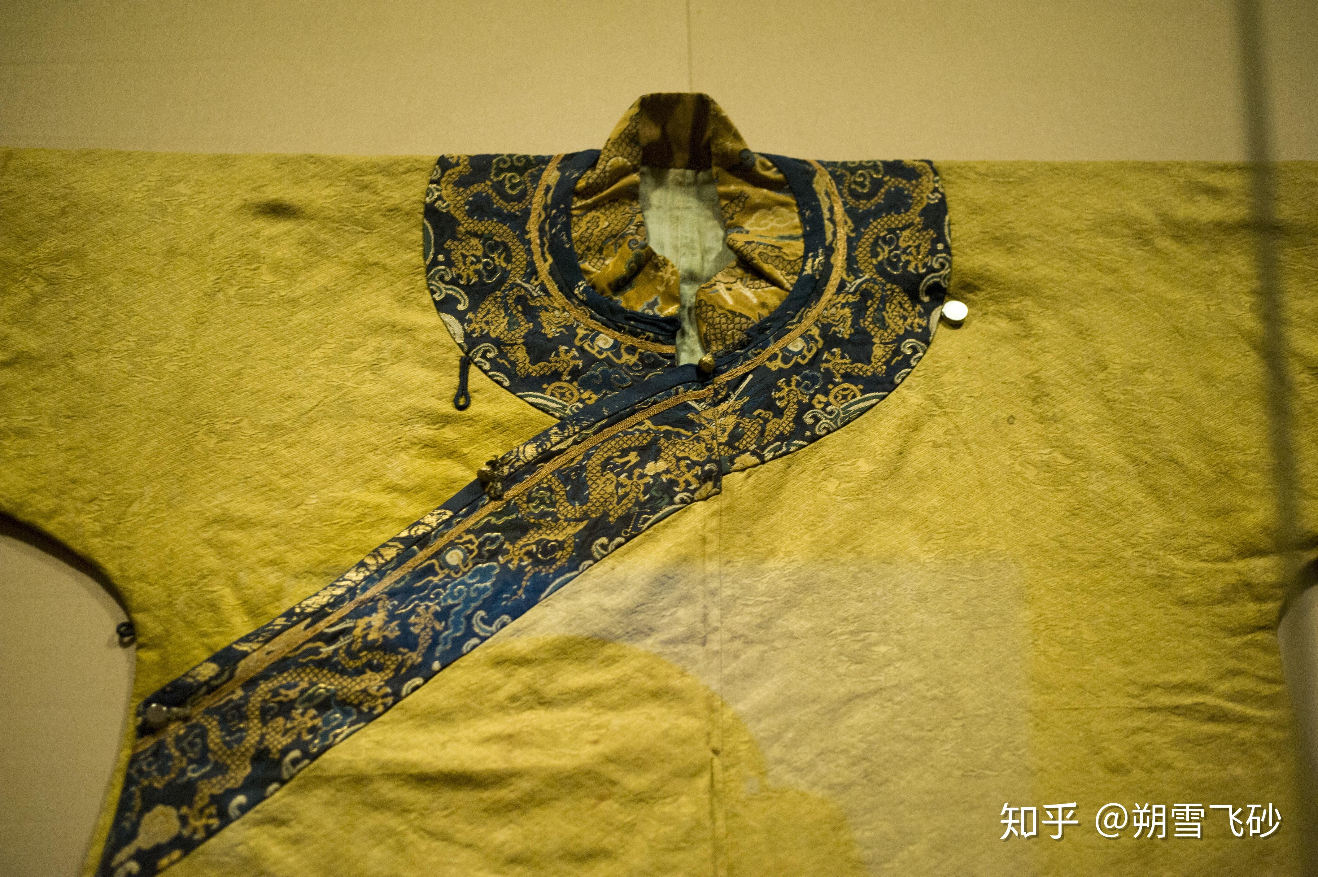 黄色锦缎上绣有暗色团龙纹和云纹,领口,开襟和箭袖(马蹄袖)部分绣有织