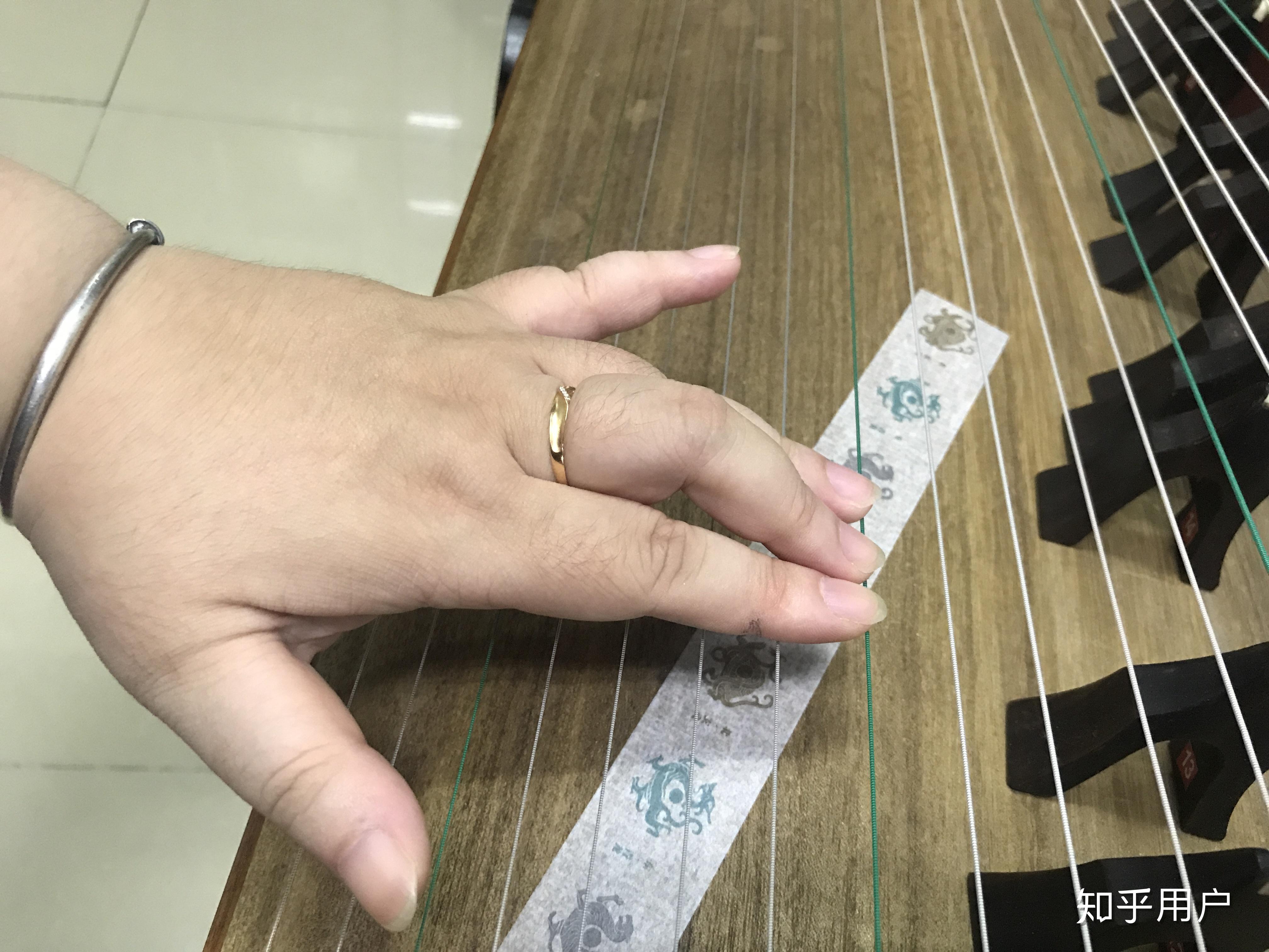 古筝左手按弦是用手指尖按,还是用手指与假指甲之间的缝隙按?