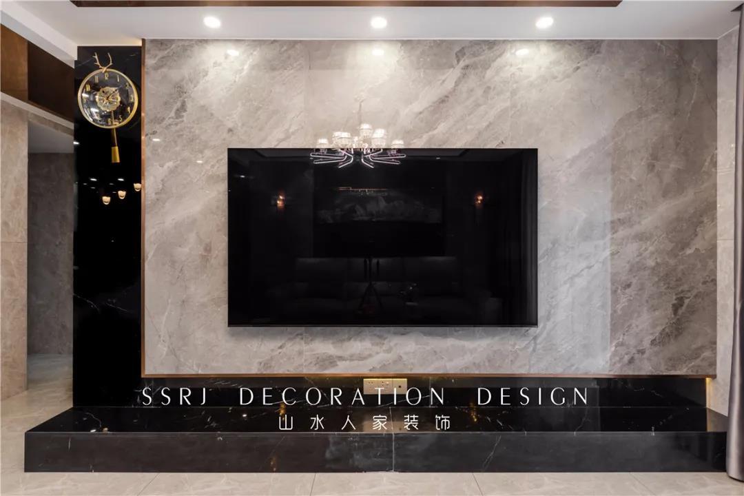 电视背景墙是云朵拉灰色的大理石,下面是黑色的地台,黑灰的色彩组合