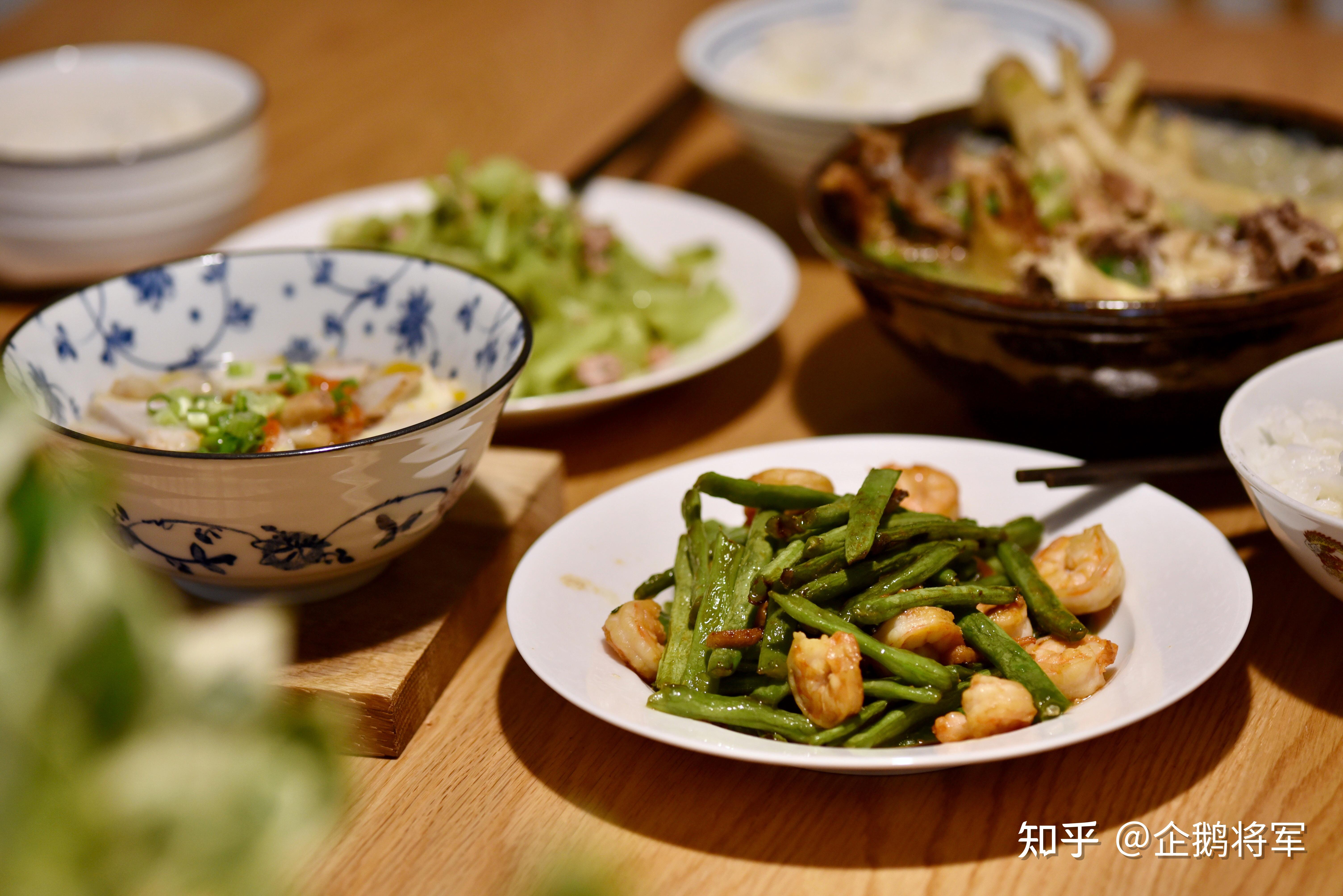 明明有一张长桌子,三口人却喜欢挤在一头,三四个菜盘子和三个饭碗还占