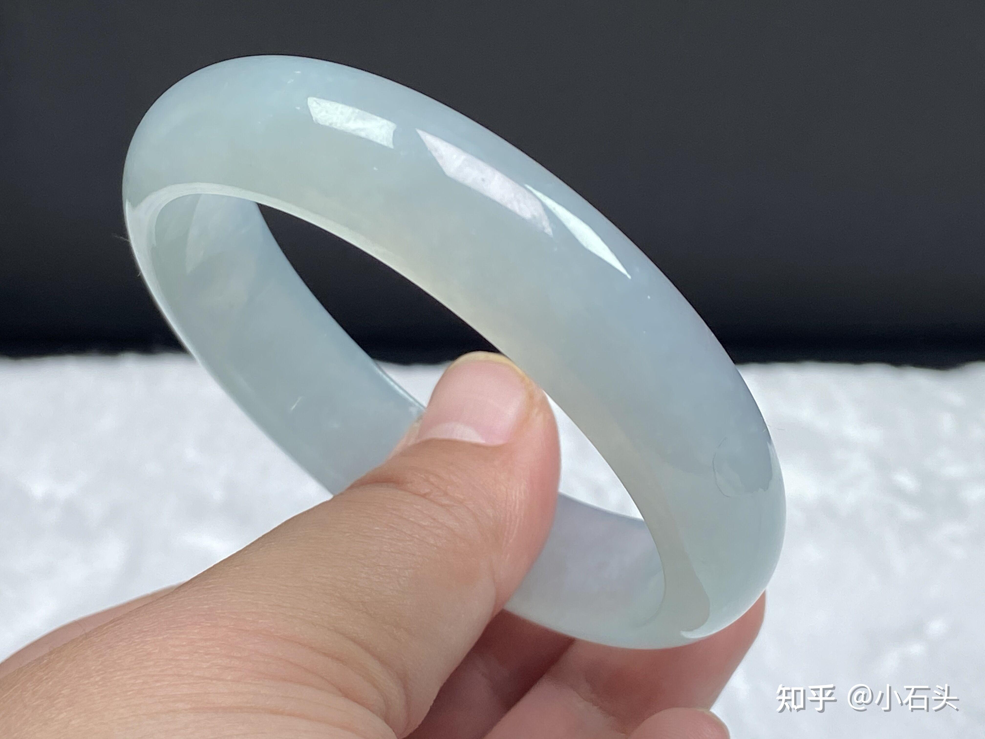 糯冰种翡翠微透光,手指放在手镯里面可以看到影子.