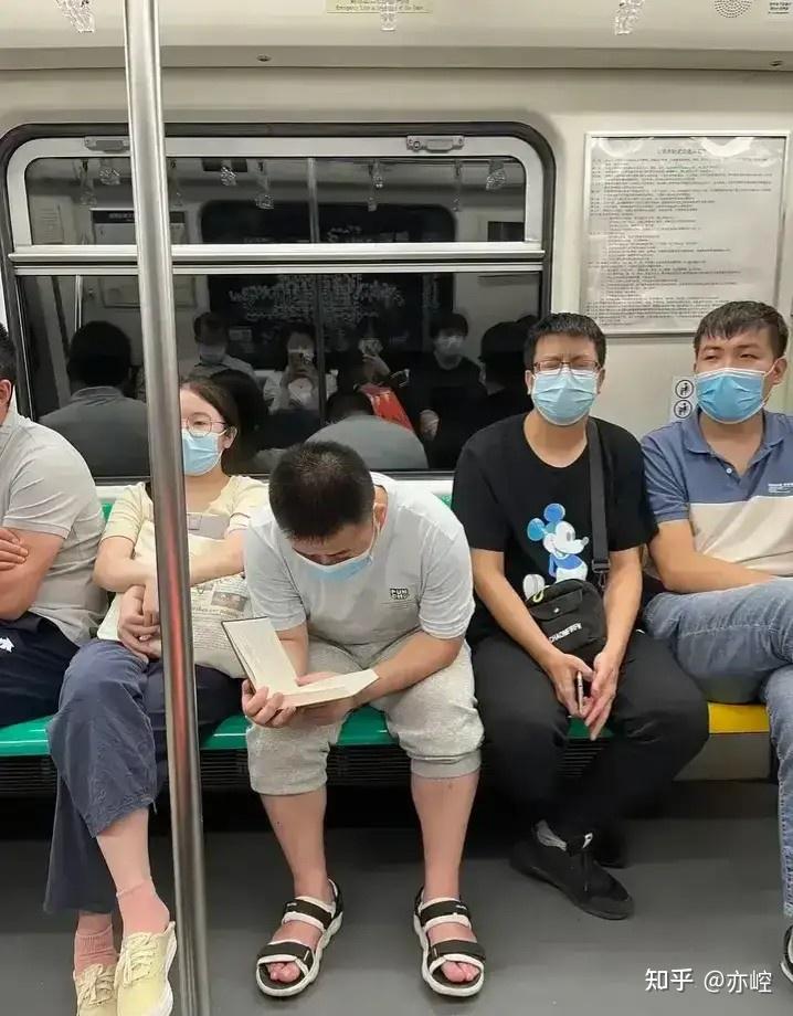 这个低头在地铁上看书的中年男人,估计每一个站点,新上来的乘客,都会