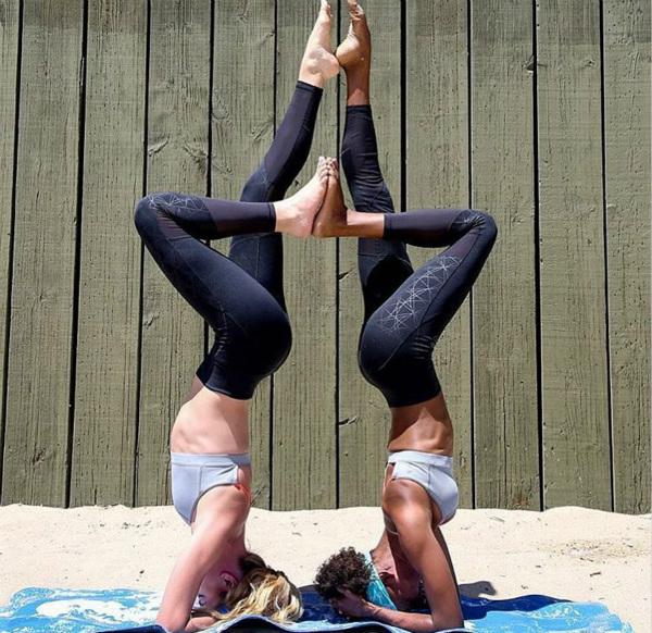 有瑜伽基础的练习者尝试双人瑜伽的头倒立动作