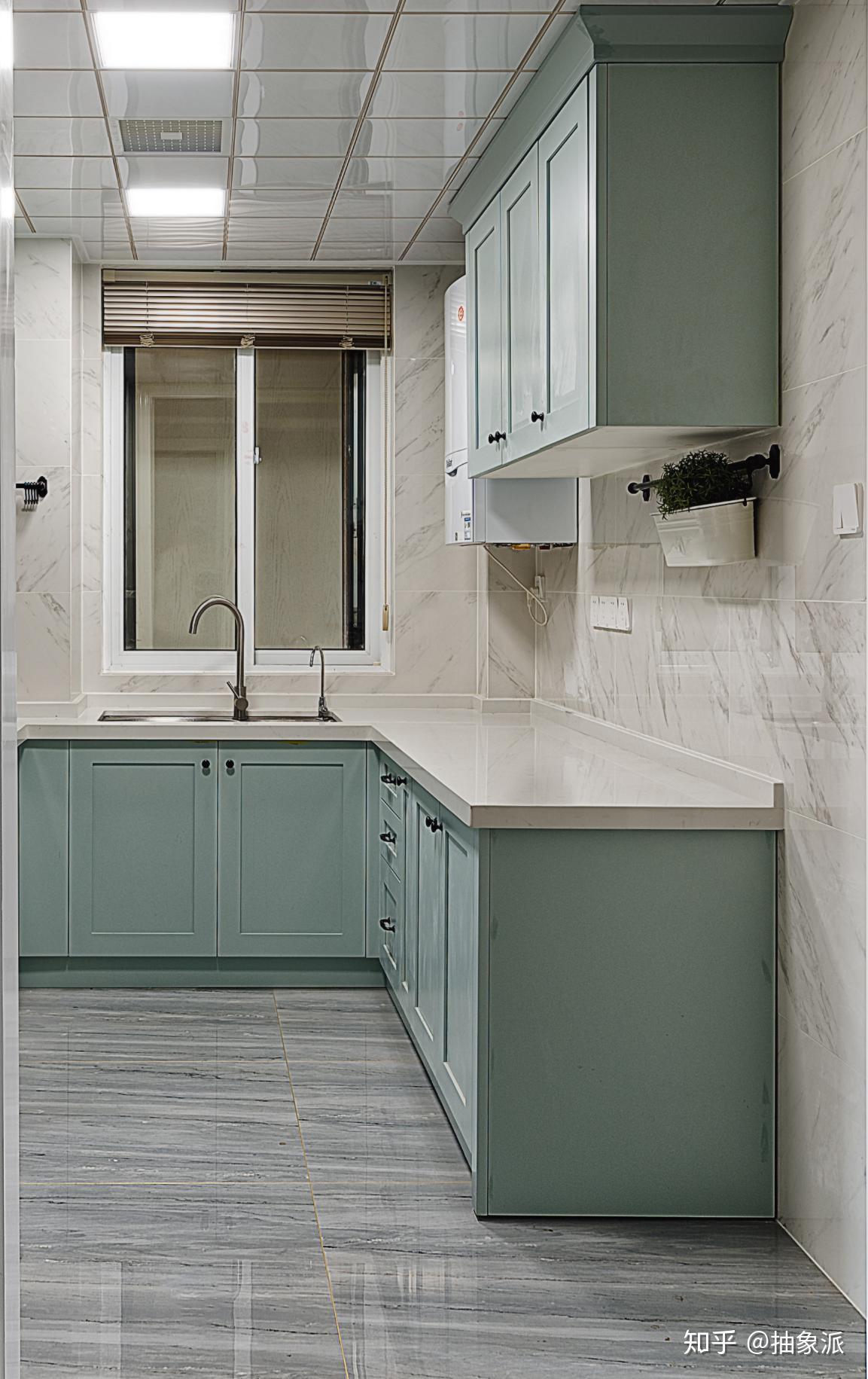 厨房千草色橱柜给人一种舒适的感觉,台面上没有摆放什么厨具,为了充分